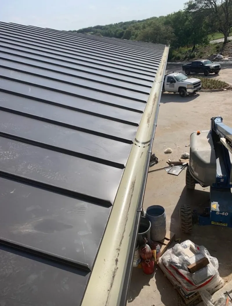 Standing seam panel and gutter detail on a metal roofing jobsite in Shawnee